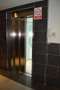 un ascensor en un baño con un cartel en la pared en The Factory Residence Hall, en Segovia