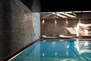 einen Pool mit 2 Lounges und einem Pool in der Unterkunft Firefly Luxury Suites in Zermatt