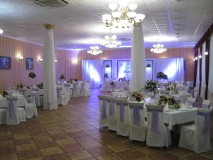 een feestzaal met witte tafels en witte gordijnen bij Hotel Dubrava in Poltava