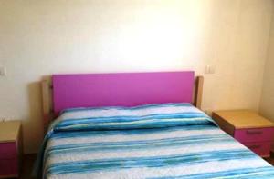 カステルサルドにあるAppartamento Lauraのベッドルーム1室(紫色のヘッドボード付)