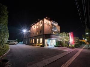 a large building with lights on the side of it at night at Annex Hotel Abe in Kurihara