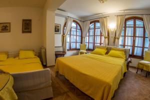 two beds in a room with yellow blankets and windows at Apartments villa MaVeRo in Banjole