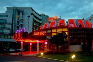 a building with red neon signs in front of it at Hotel Colosseum in Sunny Beach
