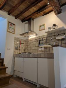 a kitchen with white cabinets and a tile wall at La Casina di Perugia in Perugia