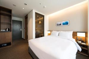Postel nebo postele na pokoji v ubytování Ramada Encore by Wyndham Busan Haeundae