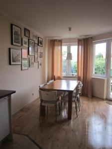 a dining room with a wooden table and chairs at Nella in Darłowo