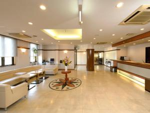 a lobby of a hospital with couches and a table at Hotel Pearl City Hachinohe in Hachinohe