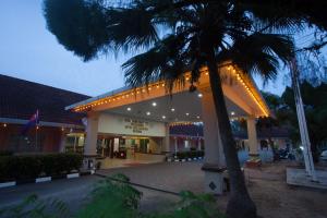 a building with a palm tree in front of it at Hotel Seri Malaysia Mersing in Mersing