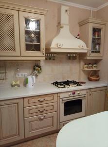a kitchen with white cabinets and a stove top oven at Apartment in historical centre in Odesa