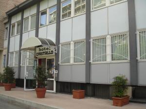 un grande edificio bianco con piante di fronte di Hotel Cristallo Torino a Torino