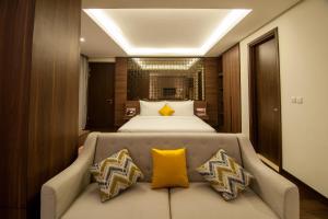 a bedroom with a bed and a couch with yellow pillows at Grand Soll Marina Hotel in Tangerang