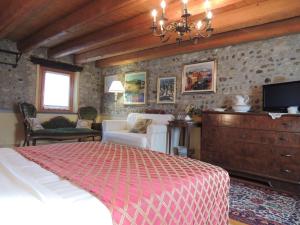 una camera con letto, divano e TV di Resort Villa Manin a Passariano