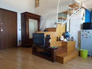 un soggiorno con TV su un centro di intrattenimento in legno di La Finestra sul Mare a Giovinazzo