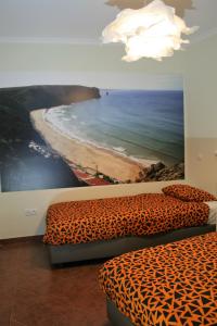 a room with two beds and a painting of the ocean at casa da ponte aljezur center in Aljezur
