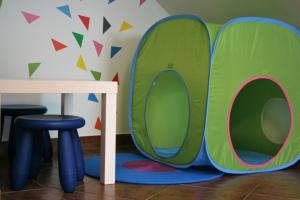 a playroom with a play tent and a table and stools at casa da ponte aljezur center in Aljezur