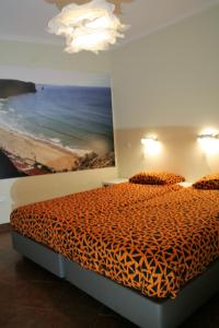 ein Schlafzimmer mit einem Bett mit einem Gemälde des Ozeans in der Unterkunft casa da ponte aljezur center in Aljezur