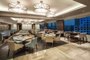 a restaurant with tables and chairs and windows at Ascott Raffles City Chengdu in Chengdu