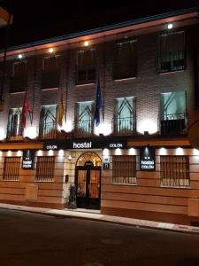 un hotel con banderas en el lateral de un edificio en Hostal Colon, en Getafe