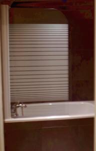 a bathroom mirror with a sink and a window at La Chaumière in Beuil