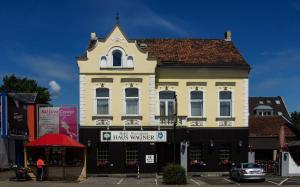 a large white building with a clock tower on a street at Hotel Haus Wagner in Frechen