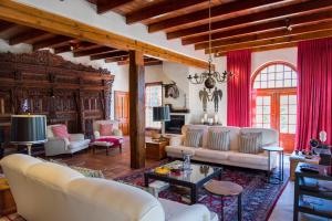 a living room with white furniture and red curtains at Kronendal Heritage in Hout Bay