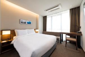 Postel nebo postele na pokoji v ubytování Ramada Encore by Wyndham Busan Haeundae