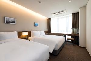 Postel nebo postele na pokoji v ubytování Ramada Encore by Wyndham Busan Haeundae