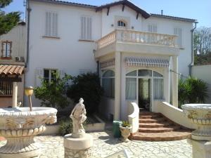 una casa blanca con una estatua delante de ella en Meublé Tourisme, en Marsella