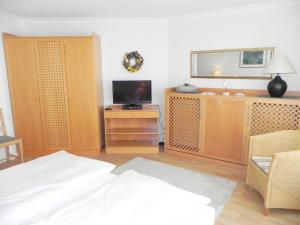 アールベックにあるFerienwohnung 2 01 Inselstrandのベッドルーム1室(ベッド1台、テレビ、木製キャビネット付)