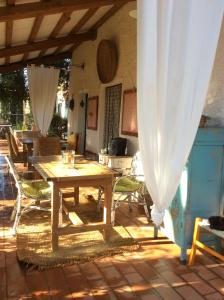 Istia dʼOmbroneにあるAt Home In Maremmaの木製テーブルと椅子付きのパティオ