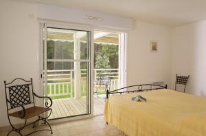 a bedroom with a bed and a sliding glass door at Madame Vacances Villas Club Royal Ocean 17 in Moliets-et-Maa