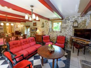 a living room with a couch and chairs and a tv at Villa 100 meters from the Atlantic in Plounéour-Trez