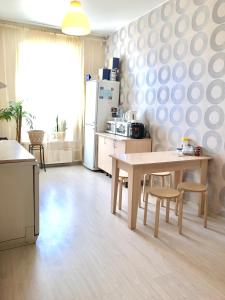 a kitchen with a table and chairs and a refrigerator at Inn Na Finskom in Saint Petersburg