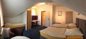 una habitación de hotel con 2 camas y una silla en Hotel Haus Wagner, en Frechen