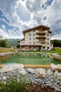 a hotel with a pond in front of a building at Apart Sonnenplateau in Serfaus