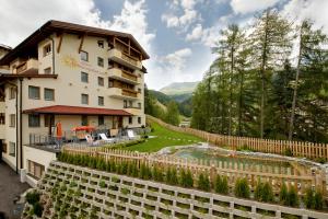 ein Hotel mit einem Garten und einem Zaun in der Unterkunft Apart Sonnenplateau in Serfaus