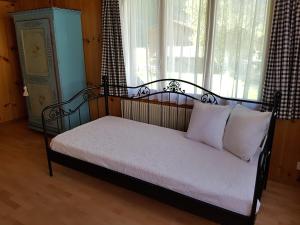 ein Bett mit weißen Kissen in einem Zimmer mit Fenster in der Unterkunft Chalet am Irfig in Kandersteg