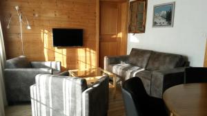 ein Wohnzimmer mit zwei Sofas und einem Tisch in der Unterkunft Chalet am Irfig in Kandersteg