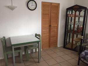 ein Esszimmer mit einem Tisch und einer Uhr an der Wand in der Unterkunft BASEMENT Links 108A 1 Zimmer Apartment in Holzminden