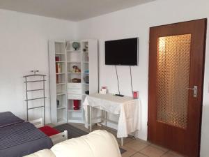 ein Zimmer mit einem Tisch und einem Fernseher an der Wand in der Unterkunft BASEMENT Links 108A 1 Zimmer Apartment in Holzminden