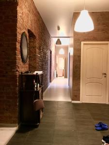 a hallway with a white door and a brick wall at Inn Na Finskom in Saint Petersburg