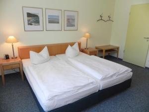 アールベックにあるFerienwohnung 2 29 Inselstrandのテーブル2台付きの客室で、白い大型ベッド1台が備わります。