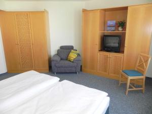 アールベックにあるFerienwohnung 2 29 Inselstrandのベッド、椅子、テレビが備わる客室です。