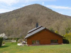 a log cabin with a mountain in the background at Cozy Cottage in Aywaille with Valley View in Aywaille