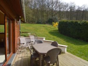 a patio with a table and chairs on a deck at Cozy Cottage in Aywaille with Valley View in Aywaille