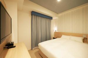 a bedroom with a large bed and a large window at Sotetsu Fresa Inn Ginza Sanchome in Tokyo