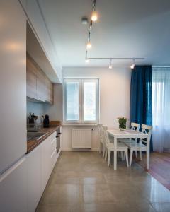 a kitchen and dining room with a table and chairs at Apartament w Piszu in Pisz