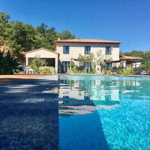 uma villa com piscina em frente a uma casa em Villa d'Arnaud em La Garde-Freinet