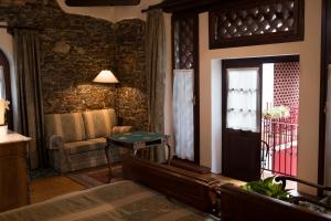 um quarto com uma porta, um sofá e uma mesa em Casali del Picchio - Winery em Cividale del Friuli
