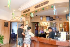 a group of people standing at a bar at Hotel Rainbow in Cameron Highlands